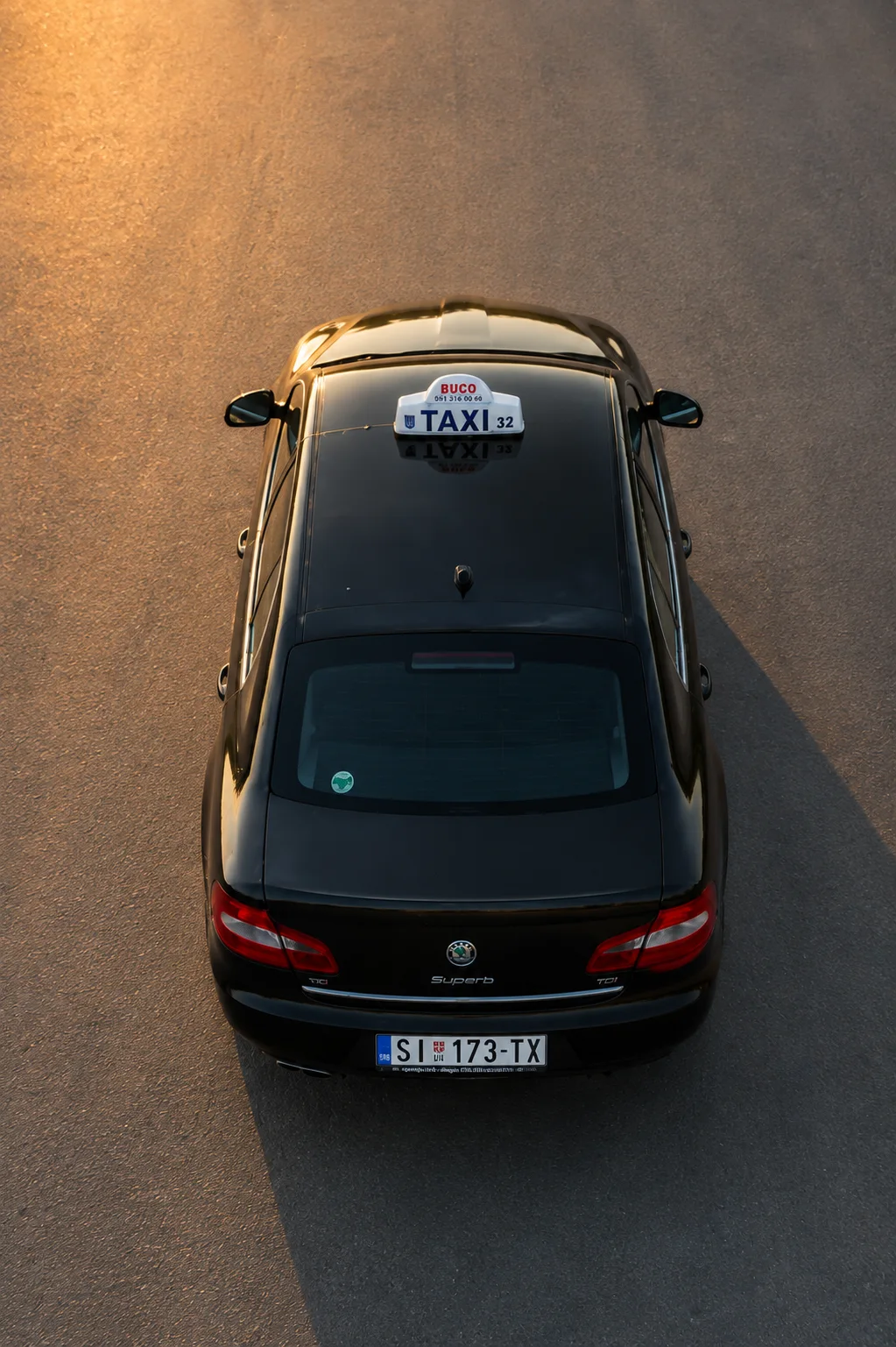 Pogled odozgo na zadnji deo taxi vozila sa krovnom oznakom